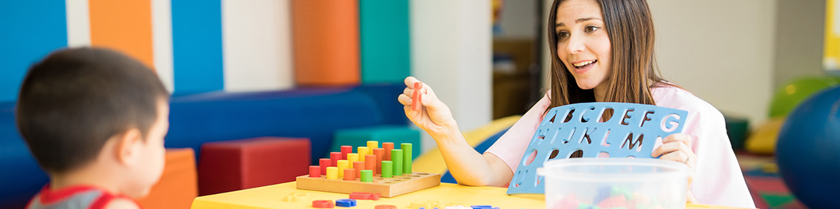 Teacher teachers a student using blocks