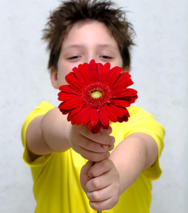 Male student holding up a flower